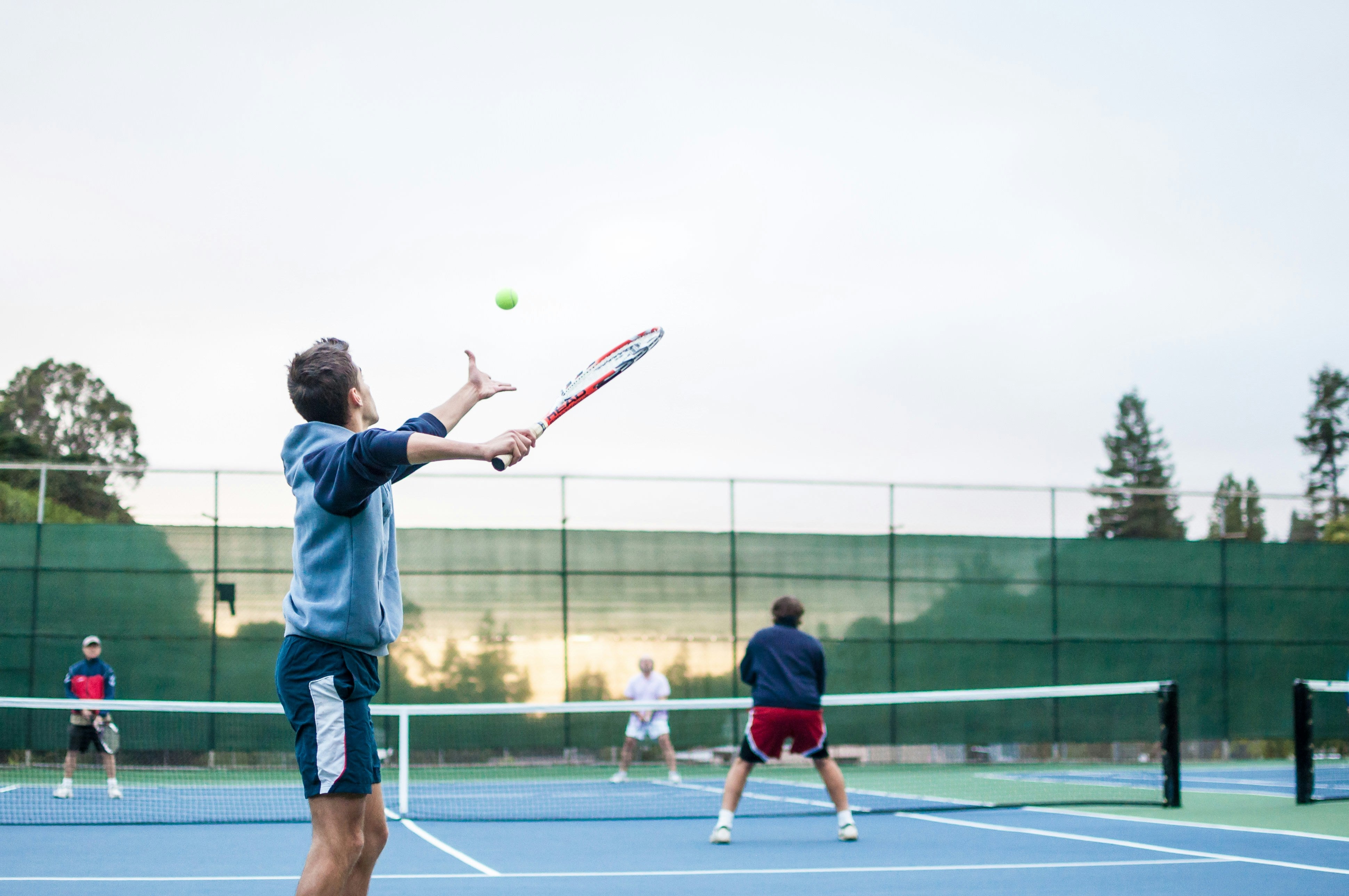 Tennis players on a court with a clear sky